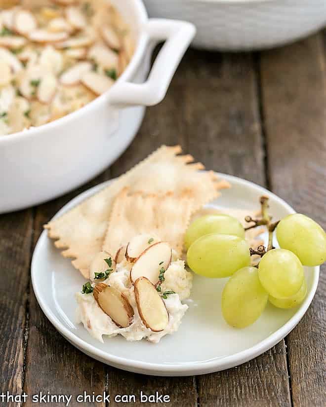 Parmesan Crab Dip on a small white plate with grapes