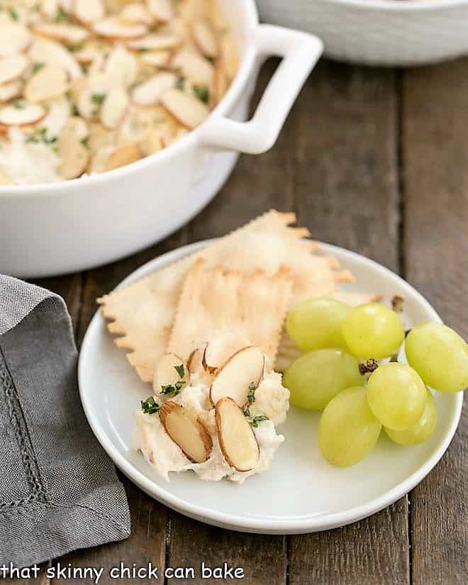 Parmesan Crab dip on an appetizer plate with crackers and green grapes