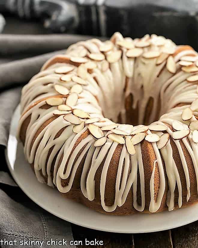 Easy Almond Bundt Cake with Amaretto Glaze on a white serving plate.