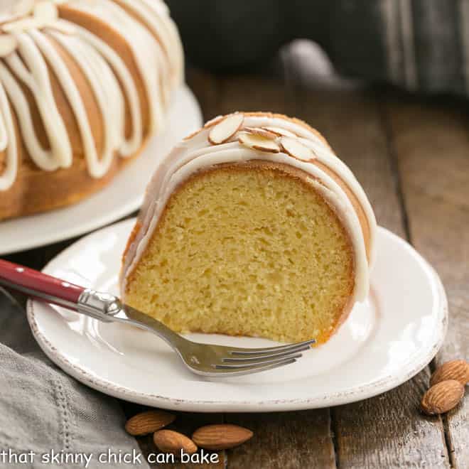 Slice of Easy Almond Bundt Cake with Amaretto Glaze on a white dessert plate.