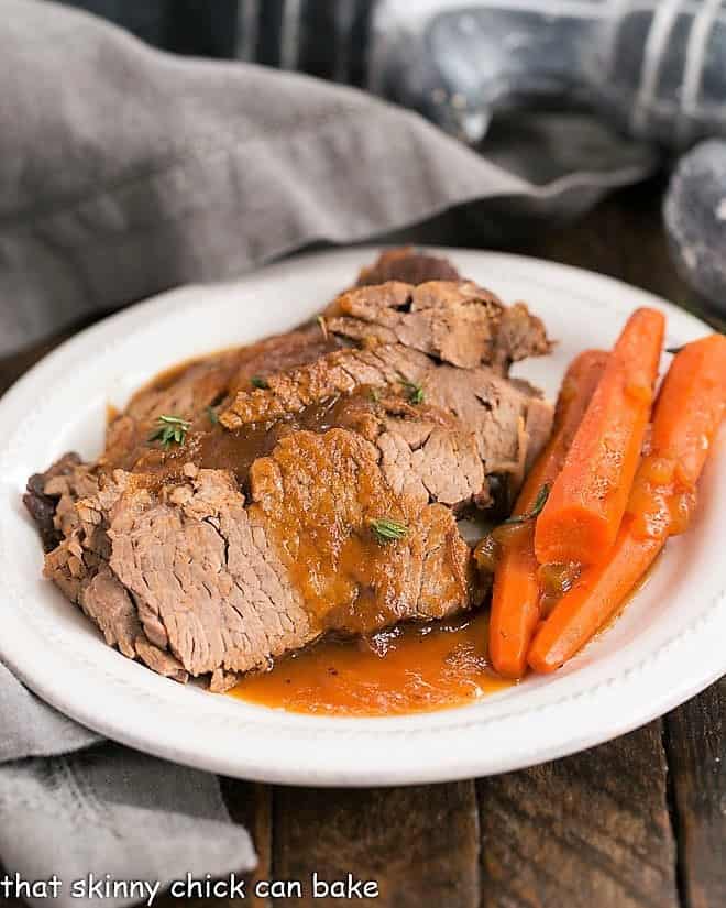 Braised Cola Brisket with Bourbon Gravy on a white dinner plate with carrots