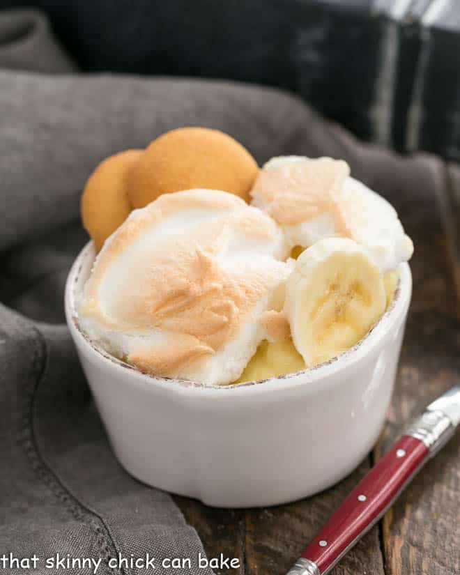 Old-Fashioned Southern Banana Pudding - a classic meringue topped vanilla pudding chock full of banana slices and a vanilla wafer crust. Old-Fashioned Southern Banana Pudding in a white bowl with a red handled spoon
