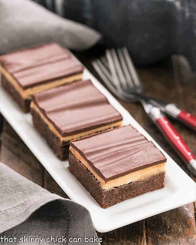 3 Peanut Butter Truffle Brownies on a white ceramic tray.