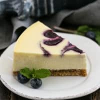 Blueberry Swirl Cheesecake slice on a white dessert plate