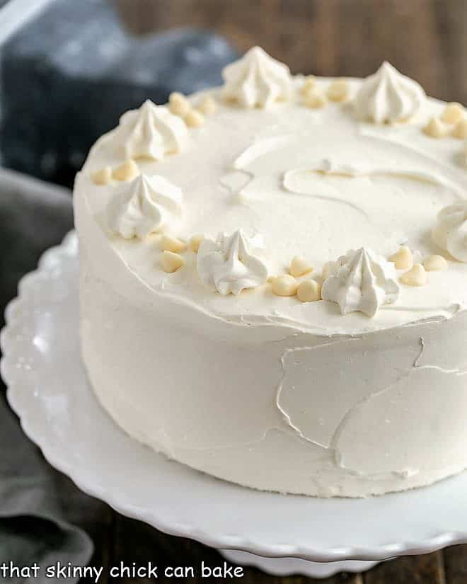 Classic White Layer Cake with White Chocolate Swiss Meringue Buttercream on a white cake stand.