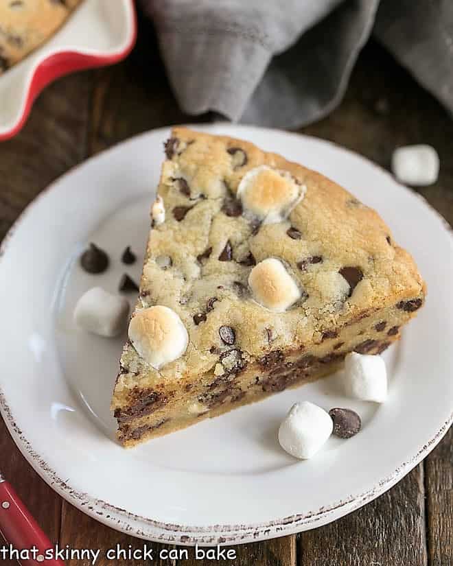 Gooey Chocolate Chip Pie wedge on a white dessert plate with marshmallows and chocolate chips.