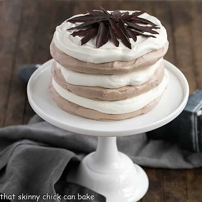 Layered Chocolate Meringue Cake on a white ceramic cake plate