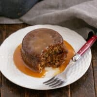 Sticky Toffee Pudding on a white plate with a red handled fork.