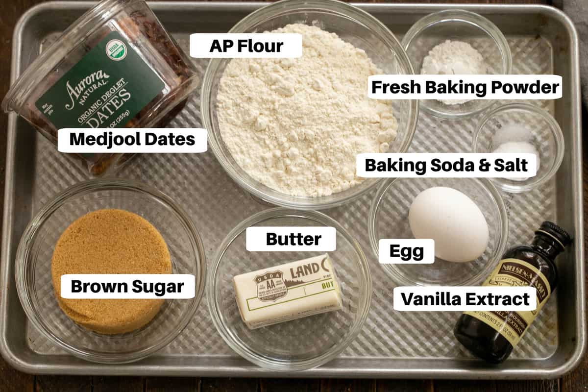 Sticky toffee pudding ingredients with labels on a metal sheet pan.