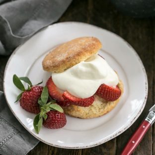 Overhead view of Strawberry Shortcakes with White Chocolate Whipped Cream on a white plate