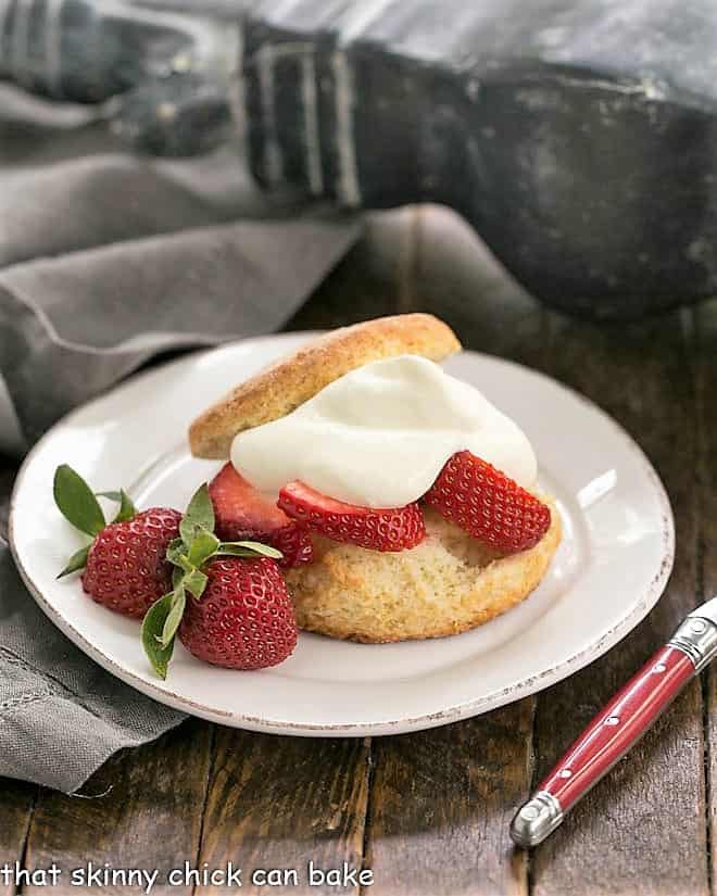 Strawberry Shortcakes with White Chocolate Whipped Cream on a white plate.