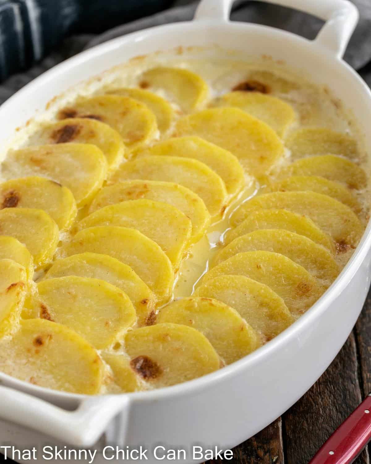 Oval casserole dish of scalloped potatoes.