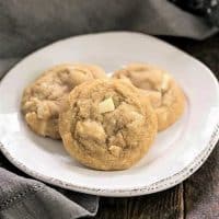 3 white chocolate macadamia nut cookies on a white plate