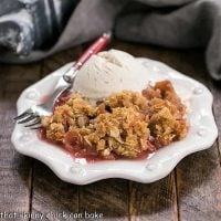 Easy Rhubarb Crisp on a white dessert plate with a scoop of ice cream