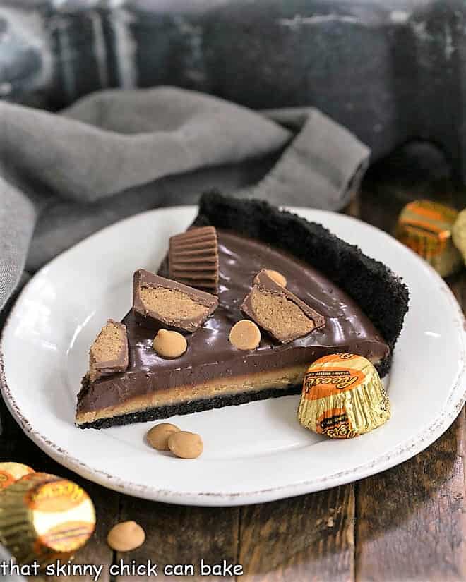 Slice of Reese's Peanut Butter Pie on a white dessert plate with mini Reeses to garnish