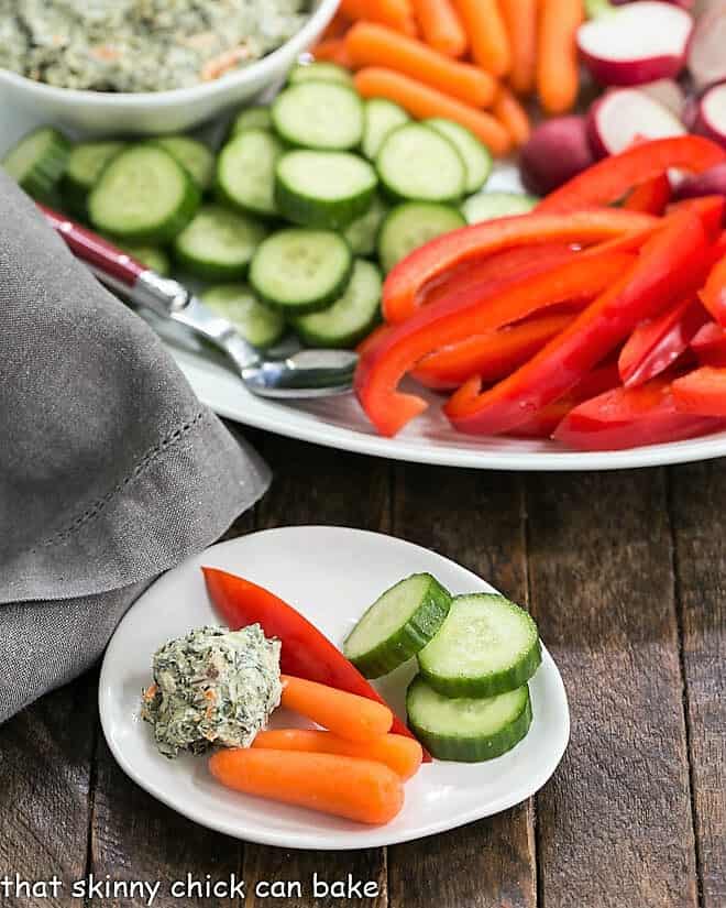 Small appetizer dish with a dollop of sour cream spinach dip and vegetables.