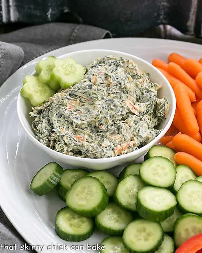 Bowl of Sour Cream Spinach Dip on a white crudite platter.