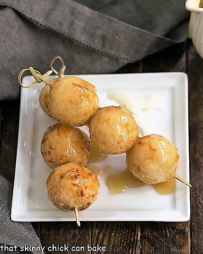Carioca or Fried Sticky Rice Balls on wooden skewers on a square white plate