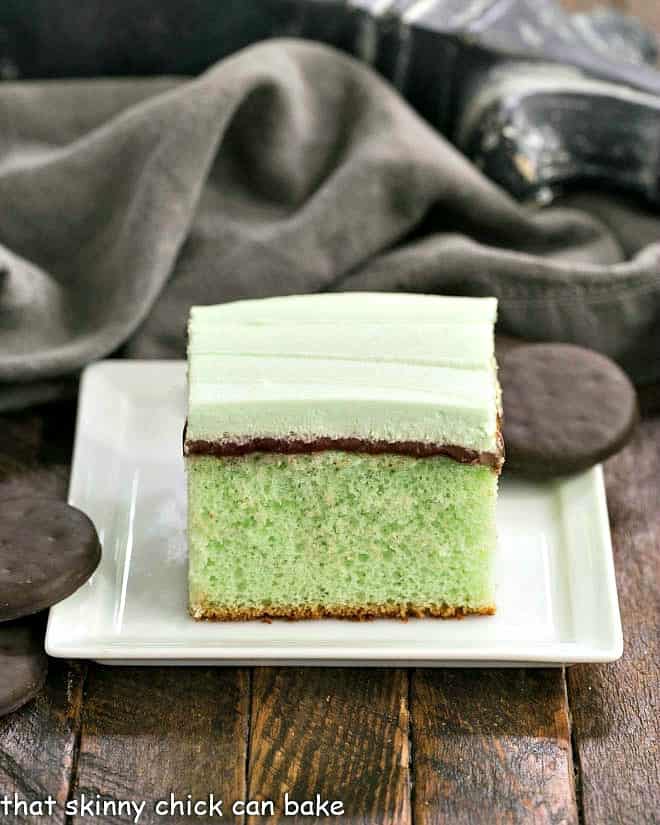 A slice of grasshopper cake on a square white plate.