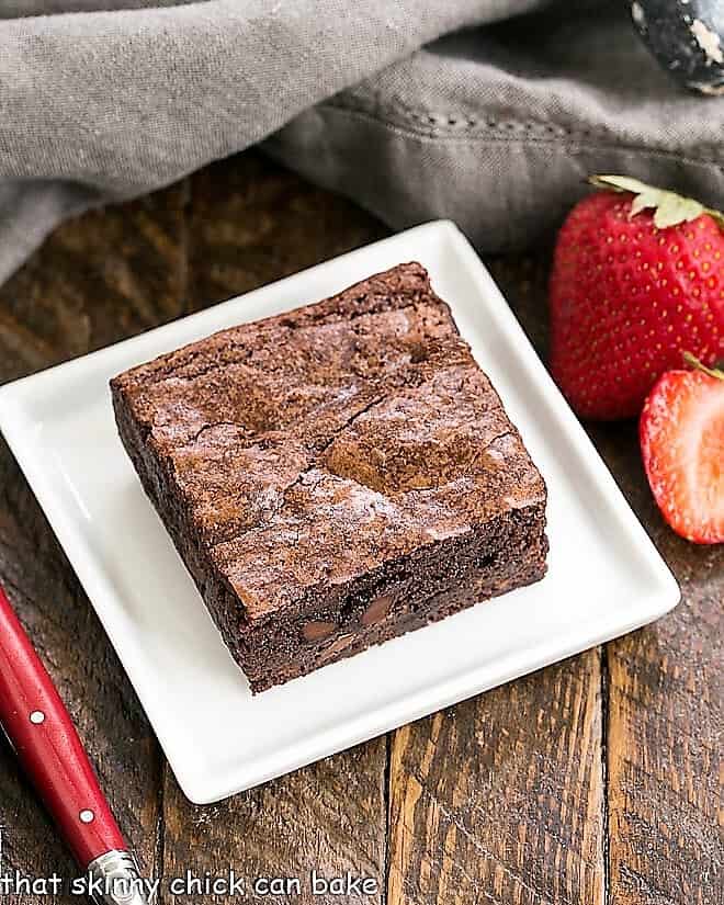 One fudgy sheet pan brownie on a square white plate