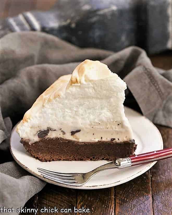 Slice of brownie baked Alaska on a white dessert plate.