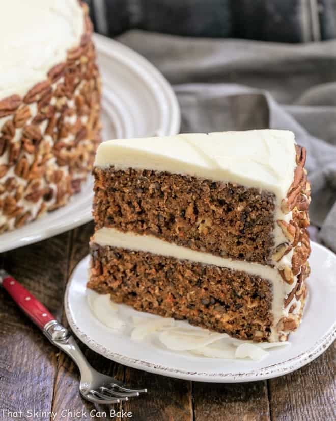 Slice of Classic Carrot Cake in a white plate with a red handled fork