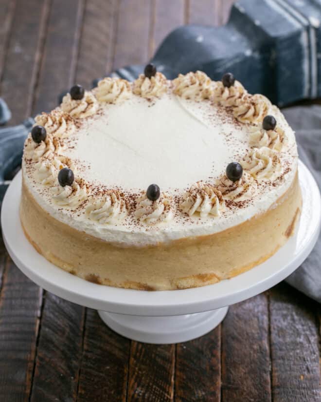 Tiramisu Cheesecake on a white ceramic cake stand.
