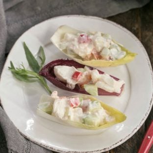 Overhead view of 3 Lobster Salad in Endive Cups on a white plate