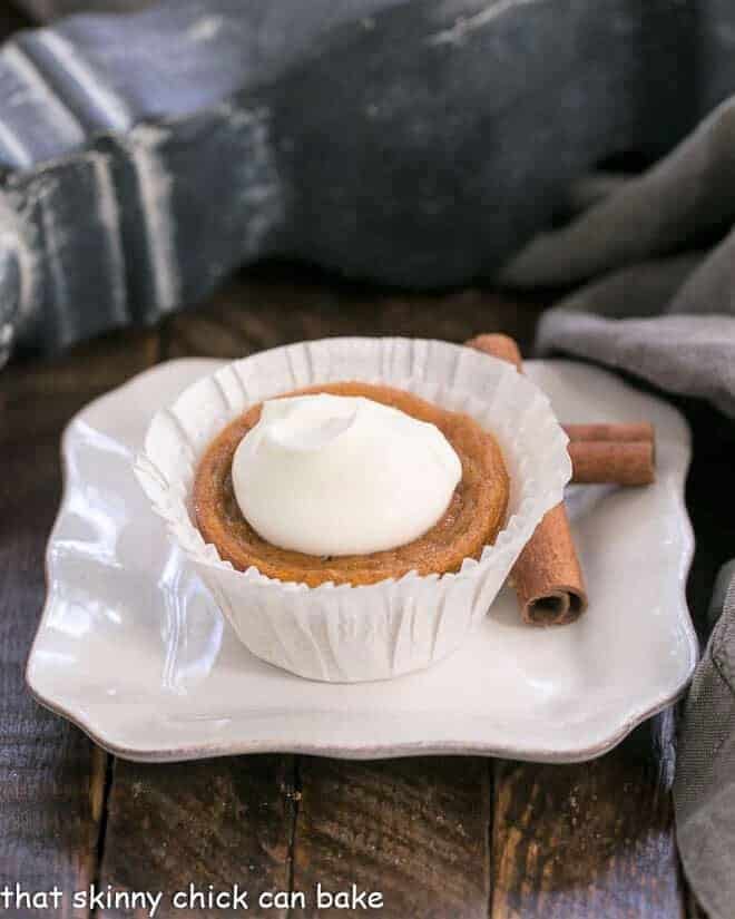 Pumpkin Pie Cupcake in a white paper wrapper on a square white plate.