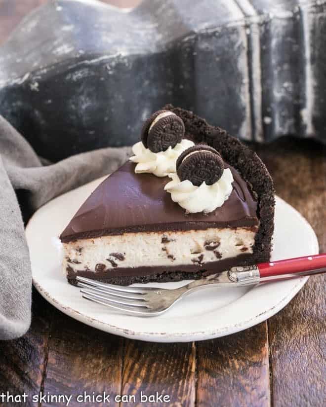 No Bake Oreo Cheesecake on a white dessert plate with a red handled fork