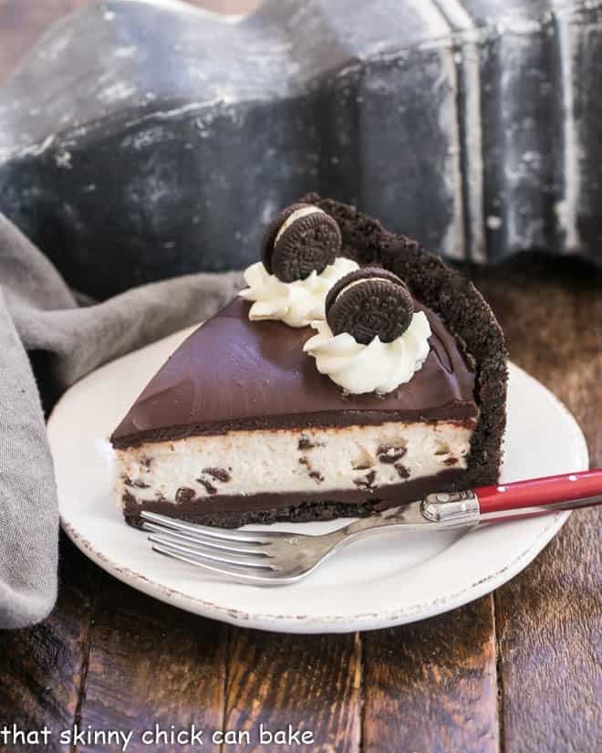 No Bake Oreo Cheesecake on a white dessert plate with a red handled fork.