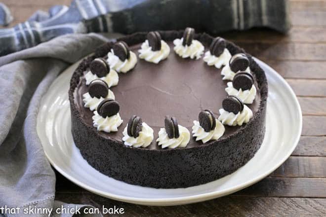 No Bake Oreo Cheesecake on a white serving plate garnished with cream roses and mini Oreos