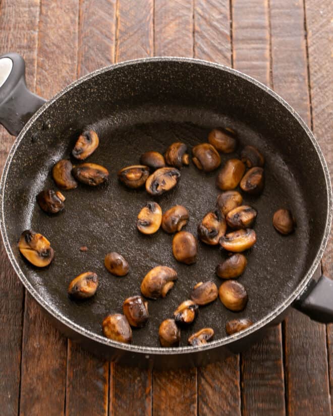 Mushrooms browned in butter in a skillet.