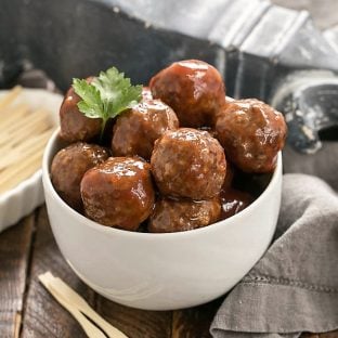 Cranberry Baked Meatballs in a white bowl with toothpicks
