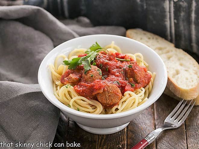 Pasta Sauce Recipe with Sausage in a white bowl with a red handled fork