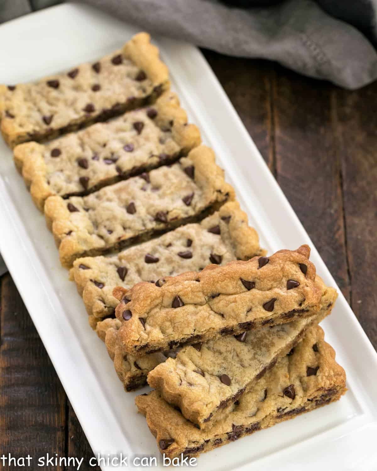 Chocolate chip cookie bars on a white ceramic tray.