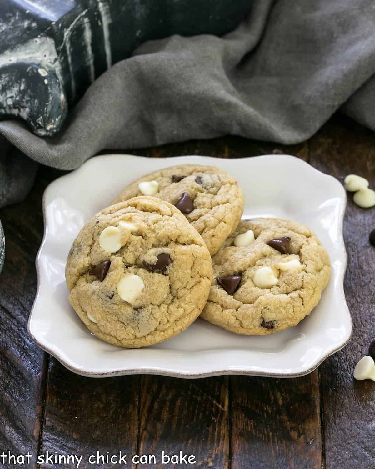 3 chocolate chip cookies with pudding on a square white plate.