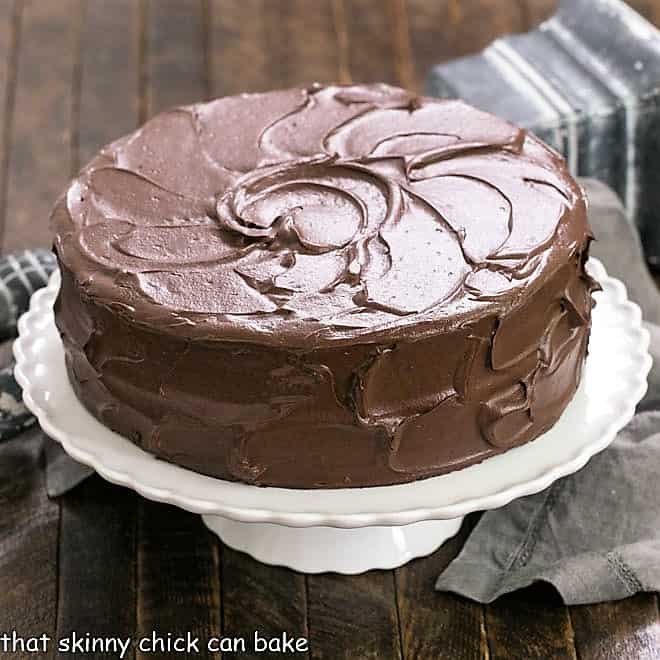 Devil's food cake on a white cake stand.