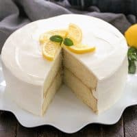 Lemon Cake with lemon curd filling on a white cake plate with a slice removed