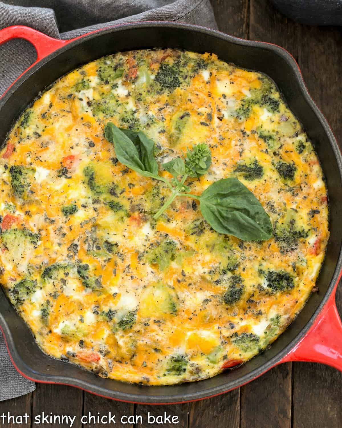 Overhead view of roasted broccoli frittata in a red cast iron pan.