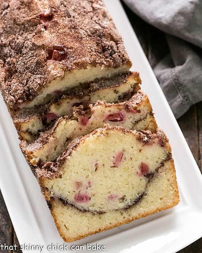 Loaf of Ciinnamon Swirl Rhubarb Bread on white platter.