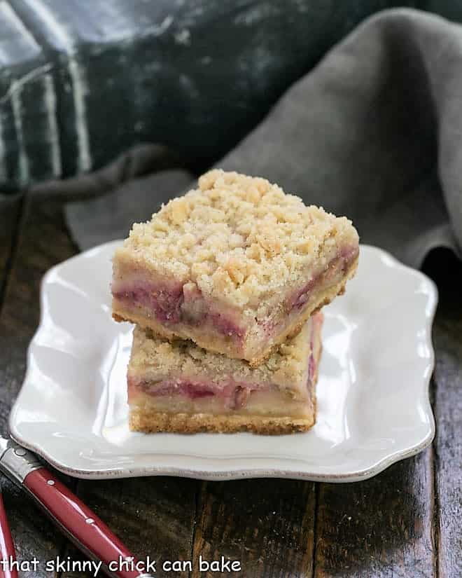 Streusel Topped Rhubarb Bars stacked on a square white plate