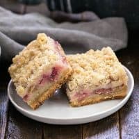 Side view of Two Streusel Topped Rhubarb Bars on a round white plate