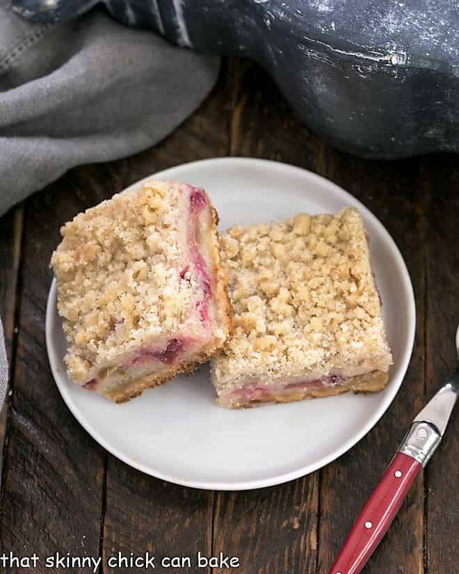 Two Streusel Topped Rhubarb Bars on a round white plate.