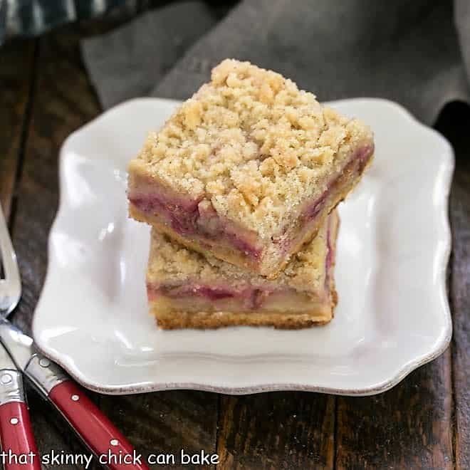 Two Two Streusel Topped Rhubarb Bars stacked on a white plate.