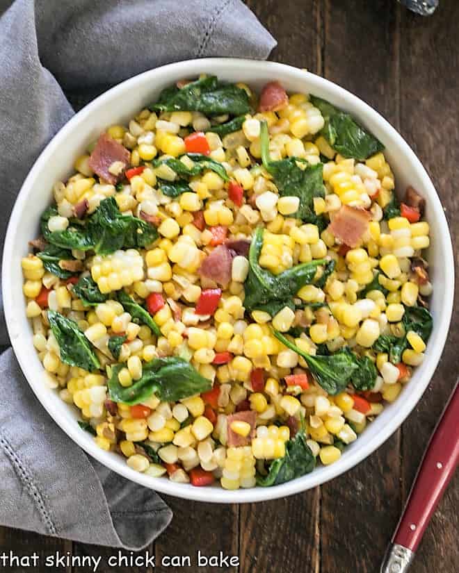 Overhead view of skillet corn with bacon in a white serving bowl.