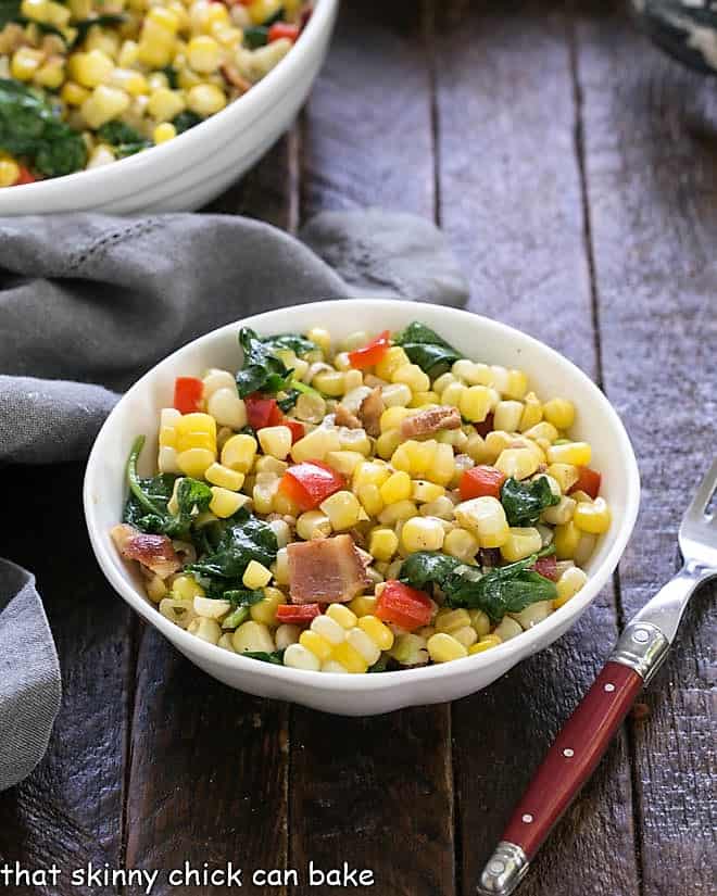 Skillet corn in a small white bowl with a red handle fork.