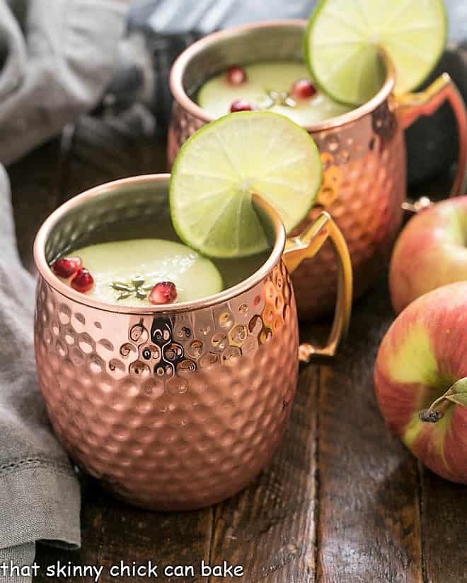 Cider Mules in copper mugs with lime and apple garnishes