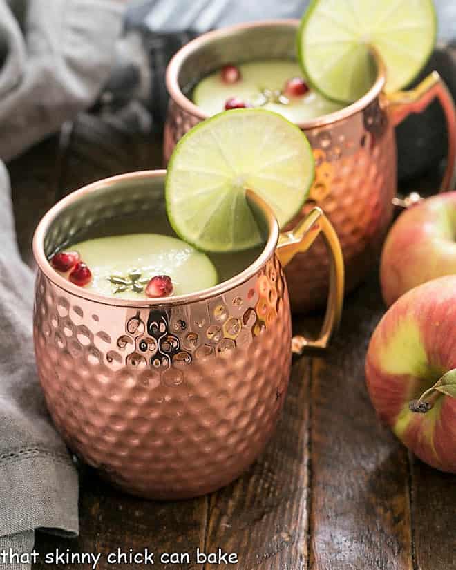 Cider Mules in copper mugs with lime and apple garnishes.