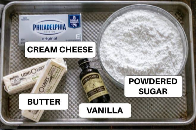 Ingredients for cream cheese frosting on a metal tray with labels.